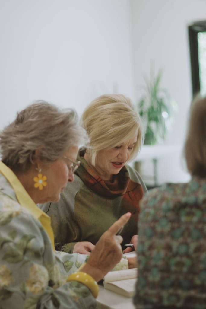 A group of women engages in a bible study in a welcoming interior space.