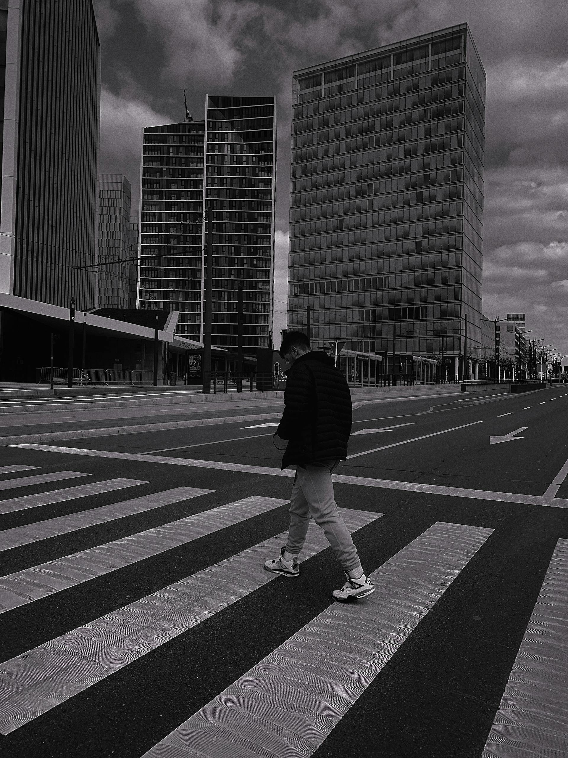 A black and white image of a man crossing a city street, reflecting how life can feel empty and colorless for someone experiencing anhedonia.